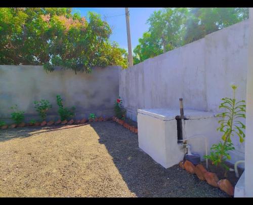 a backyard with a fence and a concrete wall at Mango garden villa in Pottuvil