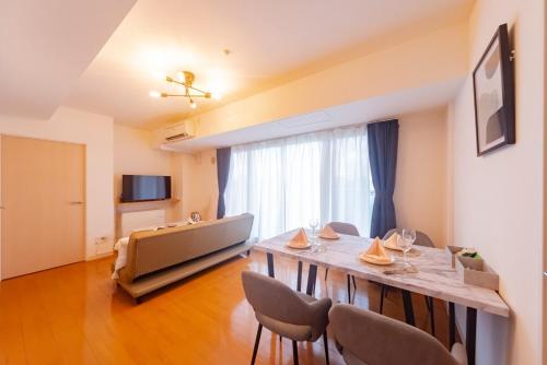 a living room with a table and chairs and a television at right next to Sapporo and Susukino!Maximum 6 people,4 minutes from the station, quiet area A177 in Sapporo