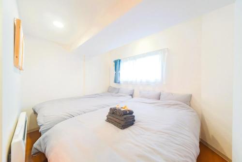 two beds in a room with white walls and a window at right next to Sapporo and Susukino!Maximum 6 people,4 minutes from the station, quiet area A177 in Sapporo