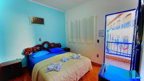 a bedroom with a bed and a large screen at Suítes por Temporada em Amparo NÃO SOMOS POUSADA in Amparo