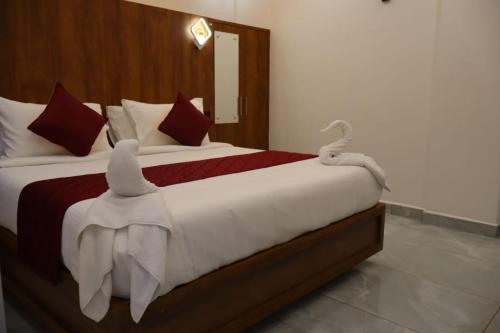 a bedroom with a large bed with white towels on it at Rhythm Stays in Munnar