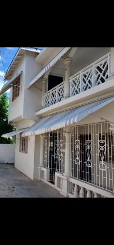 a white building with a gate in front of it at Holiday Oasis in Ocho Rios
