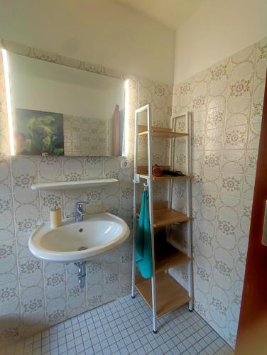 a bathroom with a white sink and a shelf at Uni nähe Unterkunft mit Garten in Bochum