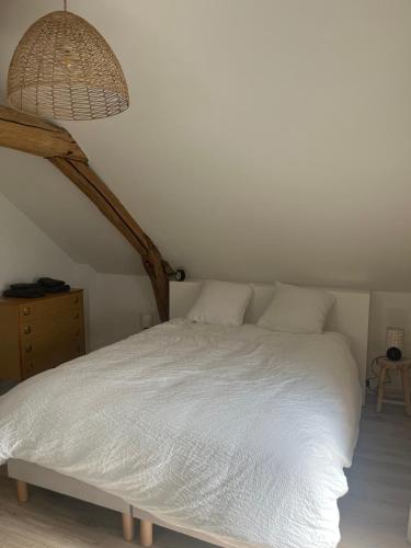 a bedroom with a white bed and a lamp at La petite Maison Mima in Le Champ-sur-Layon