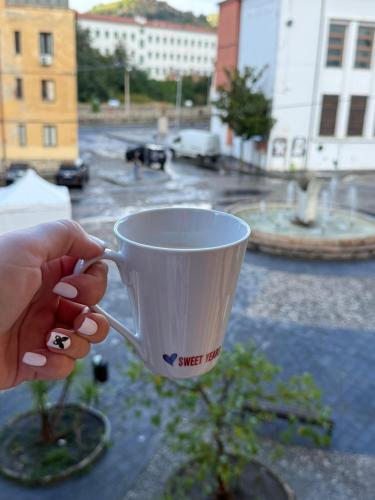 a person holding a coffee cup on a table at Casa Cenzina in Cosenza