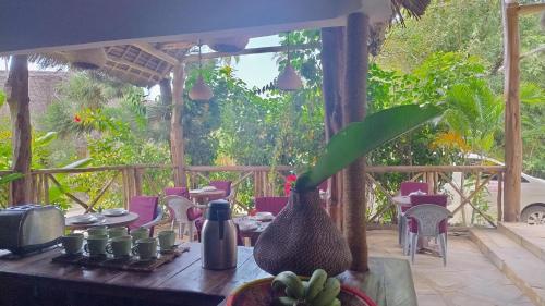 - une table avec un vase au-dessus d'une terrasse dans l'établissement Bush Paradise Kiwengwa, à Kiwengwa