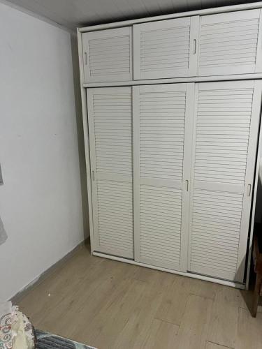 a bedroom with white closets and a wooden floor at Casa Camburi 1 in Vitória