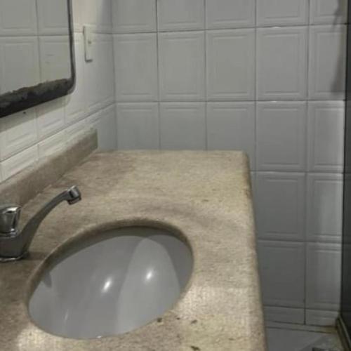 a bathroom with a sink and a mirror at Casa Camburi 1 in Vitória