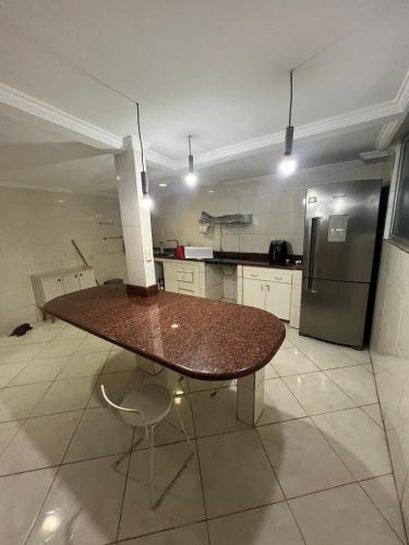 a kitchen with a table and a refrigerator at Casa Camburi 1 in Vitória