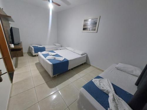 a room with two beds and a tv in it at Pousada Itaguaçu in Aparecida