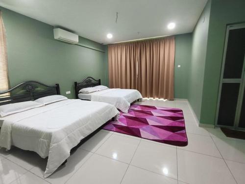 a bedroom with two beds and a purple rug at modern house Liazara homestay in Muar