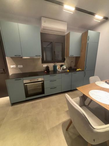 a kitchen with blue cabinets and a table with a chair at Five shades of blue in Vourvourou