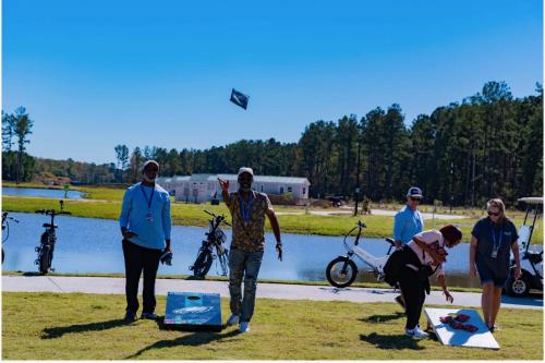 a group of people flying a kite near a lake at Savannah Lakes RV Resort in Hardeeville