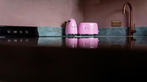 two pink cups sitting on a counter in a bathroom at Maison Rokxy - Luxury Apartments in London
