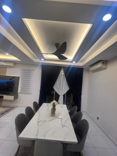a dining room with a table and chairs and a ceiling at Kj Resident Homestay in Alor Setar
