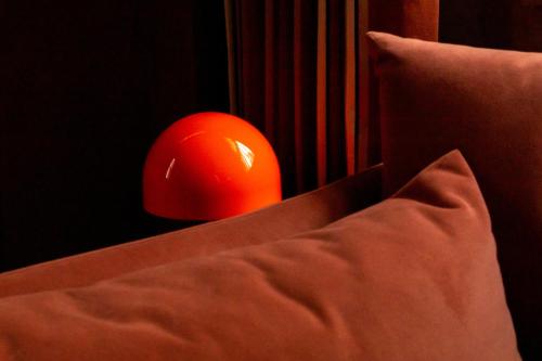 an orange ball is sitting next to a pillow at Maison Rokxy - Luxury Apartments in London