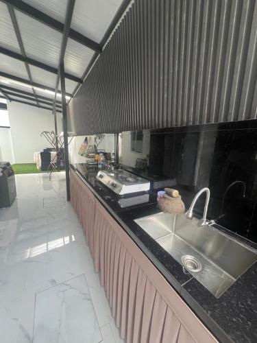 a kitchen with a sink and a counter top at Kj Resident Homestay in Alor Setar