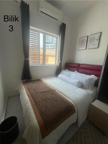 a bedroom with a large bed with a window at Kj Resident Homestay in Alor Setar