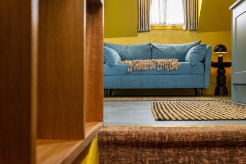 a blue couch sitting in a living room at Maison Rokxy - Luxury Apartments in London