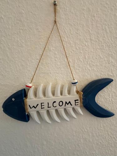 a whale ornament hanging on a wall with the word welcome at Apartment schöner Ausblick in Wendtorf