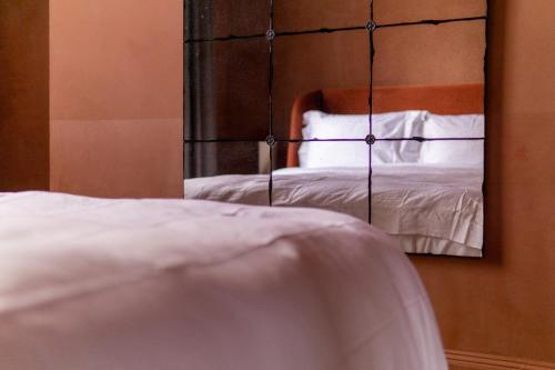 a mirror in a bedroom with a bed in it at Maison Rokxy - Luxury Apartments in London