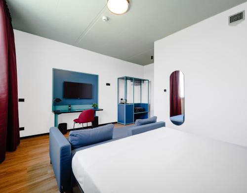 a bedroom with a bed and a couch and a tv at CX Modena Crocetta in Modena
