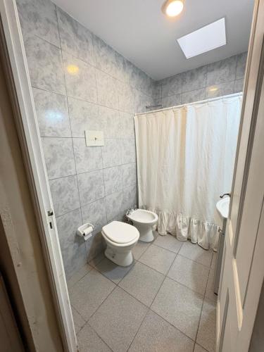 a bathroom with a toilet and a shower at Casa verde in Cañada Rosquín