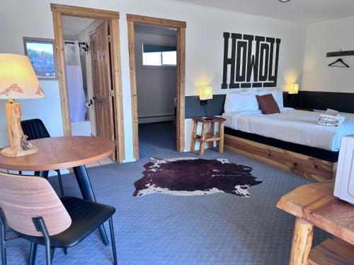 a hotel room with a bed and a table and chairs at Elk Antler Inn in Thermopolis