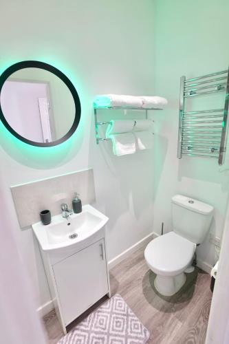 a bathroom with a white toilet and a mirror at 2 Bedroom Apartment Southsea - Sleeps 5 & Free Parking in Portsmouth