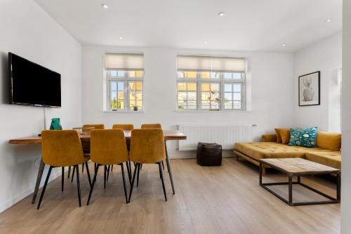 a living room with a table and chairs and a couch at 2 Centralt beliggende og lyst indrettet lejlighed in Skagen