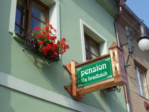 a sign on the side of a building with a window at Penzion Na Hradbách in Louny