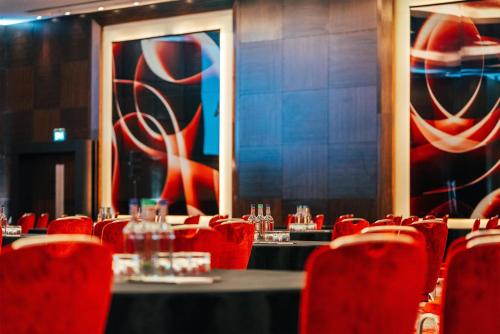 a dining room with red chairs and tables with glasses at Park Plaza London Westminster Bridge in London