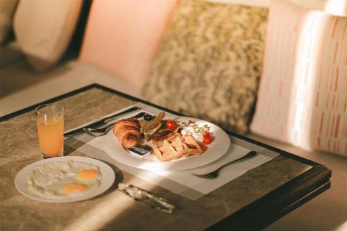 uma mesa com dois pratos de comida e um copo de suco de laranja em Radisson Resort Phan Thiet em Phan Thiet