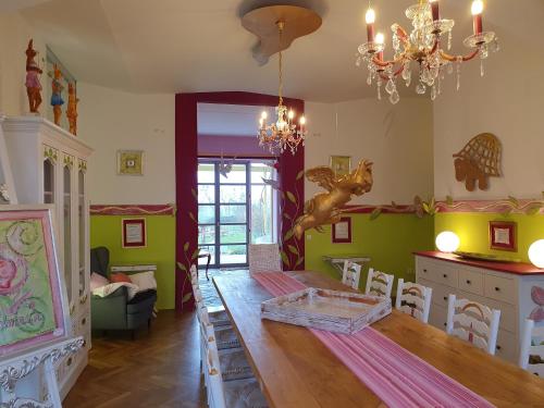 a dining room with a long table and chairs at Kunstgut Patapaya in Neukalen