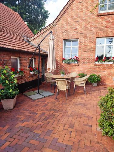 a patio with an umbrella and a table and chairs at Ferienwohnung-Ohetal in Breddenberg