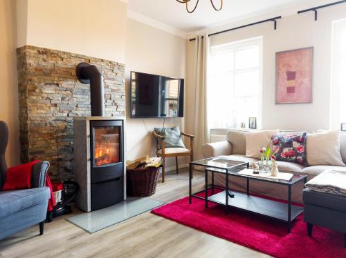 a living room with a couch and a fireplace at Ferienwohnung-Ohetal in Breddenberg