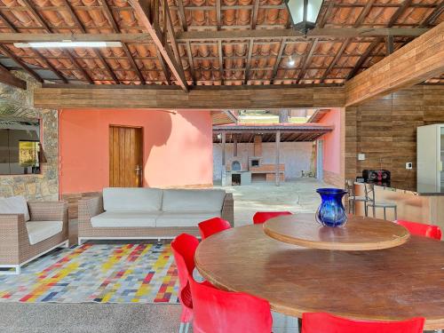 a living room with a table and red chairs at Refúgio Natureza Piscina Sala de Jogos Lazer in Campo Limpo Paulista