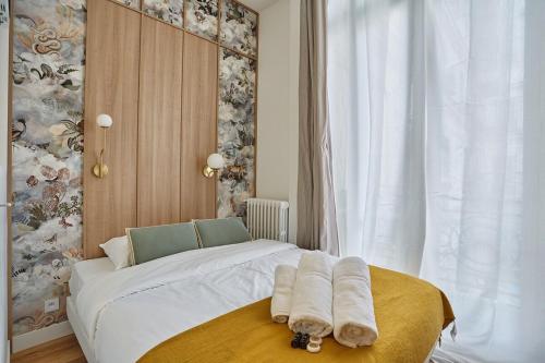 une chambre avec un lit avec des serviettes dessus dans l'établissement Apartment on the Champs Elysees, à Paris