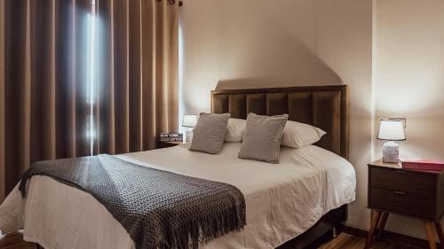 a bedroom with a large bed with two pillows at Elegant Suite in Santa Cruz de la Sierra