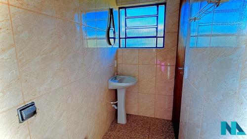 a bathroom with a sink and a window and a shower at Suítes por Temporada em Amparo NÃO SOMOS POUSADA in Amparo