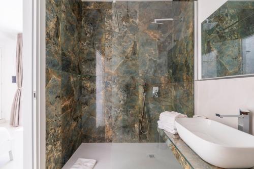 a bathroom with a sink and a bath tub at Pietra di Luna Domo in Baunei