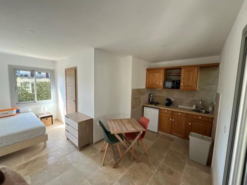 Una pequeña cocina con una cama, una mesa y sillas. en Studio 1, en Roquebrune-sur-Argens