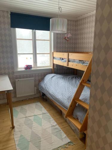 a bedroom with a bunk bed and a window at Stuga nära sjö och skog in Bengtsfors