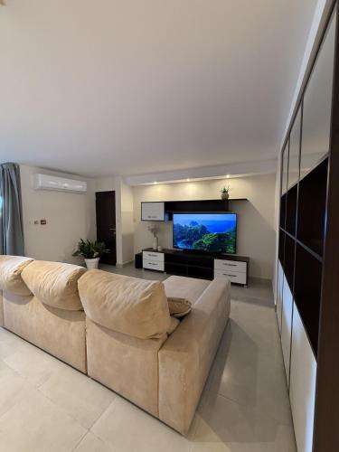 a living room with a large couch and a flat screen tv at City Stay B&B in Taʼ l-Imgħajjen