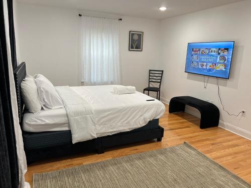 Un dormitorio con una cama y una silla dentro. en Blissfully Large 3 bedroom 3 king beds newark airport, en Newark