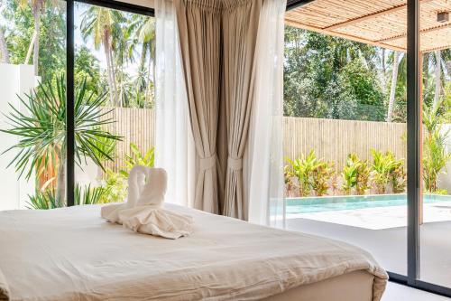 sypialnia z łóżkiem i dużym oknem w obiekcie Luxury K Villa 02 w mieście Ko Phangan