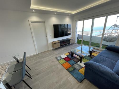 a living room with a blue couch and a tv at Sky Suites Alicante in Alicante