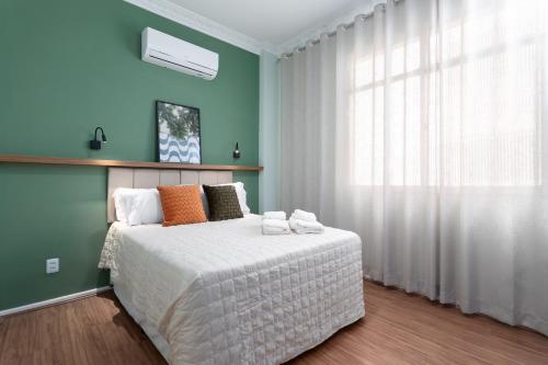 a bedroom with a large bed with a window at Studio em Botafogo a 150m do metrô in Rio de Janeiro