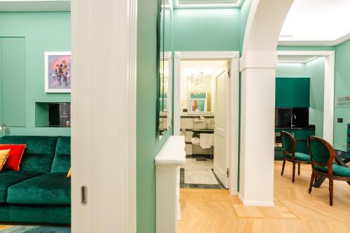 a living room with a green couch and a dining room at Art Hotel Commercianti in Bologna