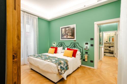 a bedroom with green walls and a bed with orange pillows at Art Hotel Commercianti in Bologna